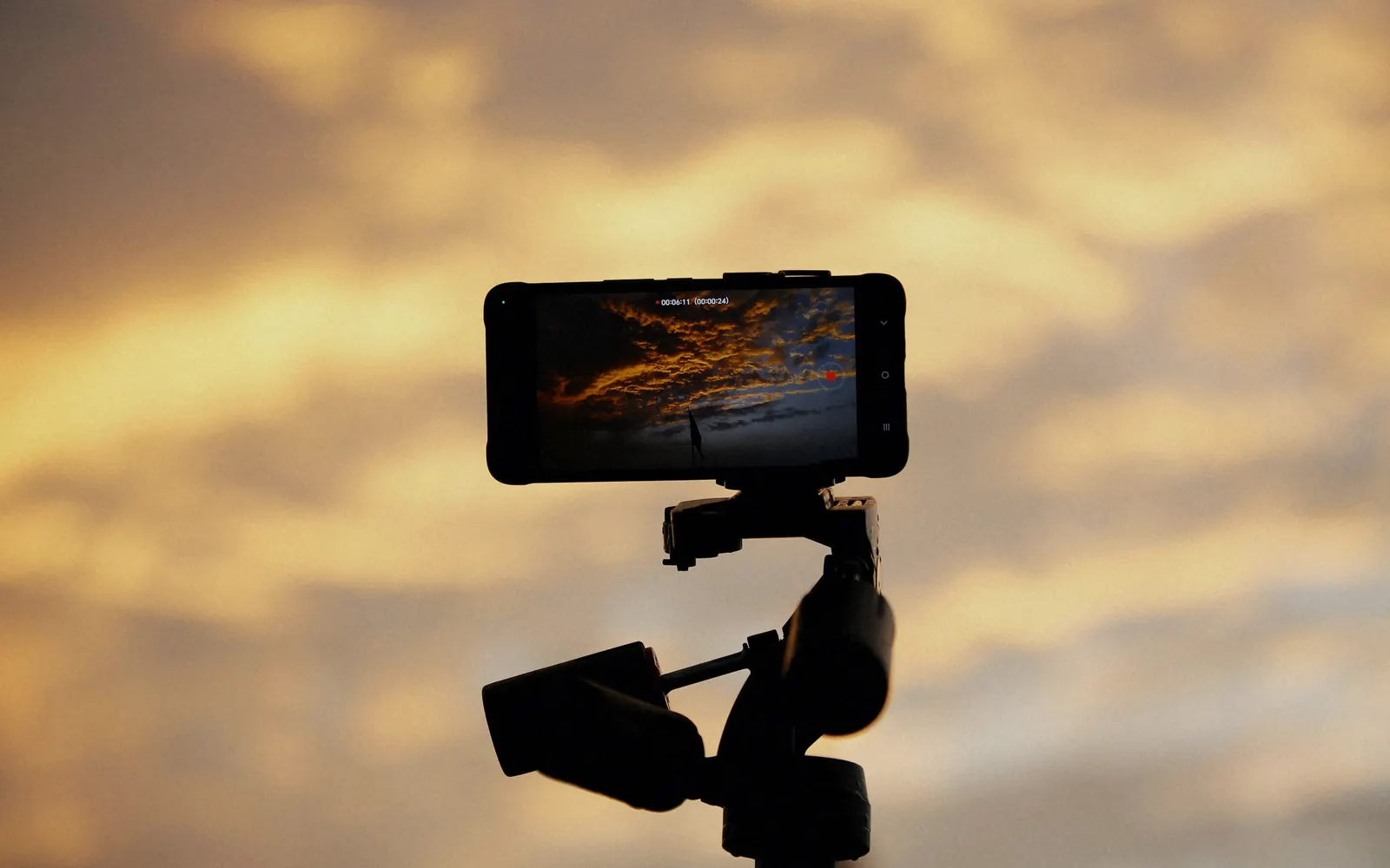 Smartphone on a tripod filming a sunset sky